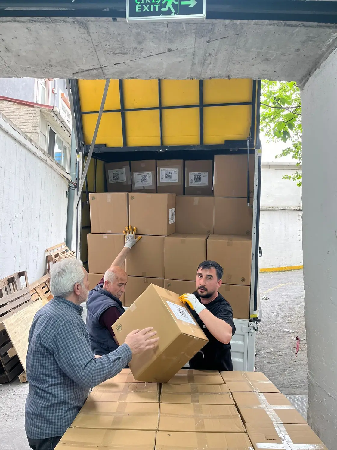 Bakır Nakliyat ekibi yükleme rampasında kolileri elden ele indiriyor