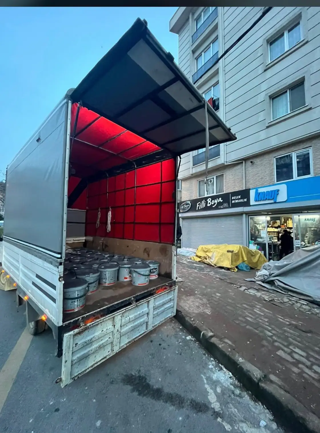 Yapı market önünde araçtan indirilmeyi bekleyen boya kovaları